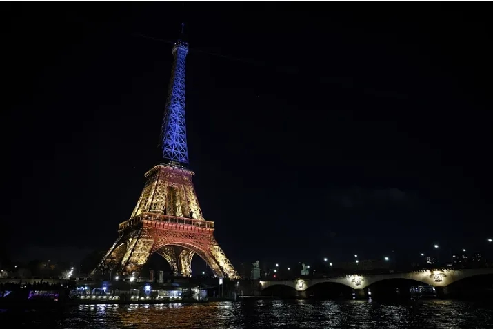 Centenas reuniram-se perto da Torre Eiffel iluminada com as cores do país